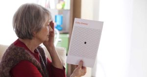 Sarı nokta hastalığı şüphesi olan kişi Amsler Grid kartına bakarak evde görme kontrolü yapıyor.